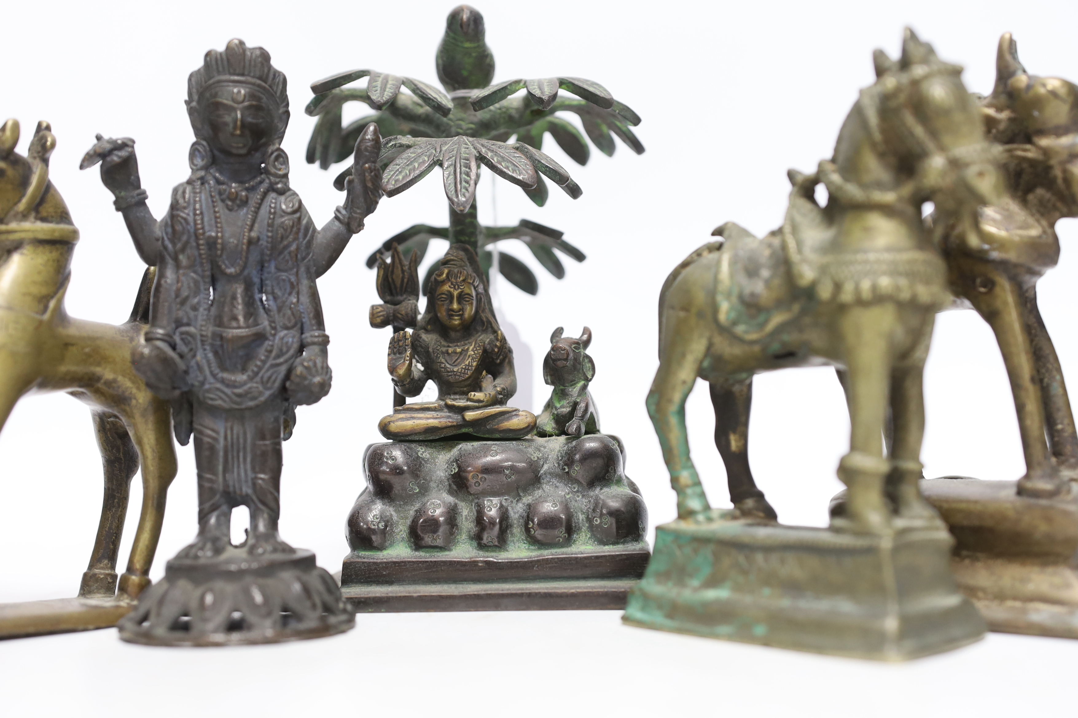 Six Indian bronze/brass ornaments; Shiva sitting under a bael tree with a bird, 17cm, two figures of Lord Vishnu and three horses